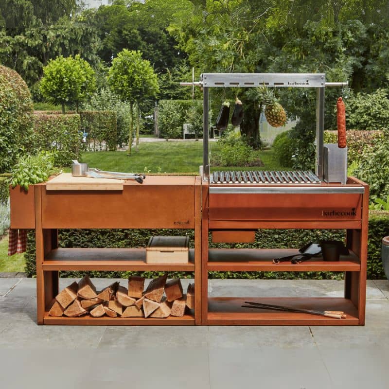 Wooden outdoor grill station with firewood and a grill in a garden setting