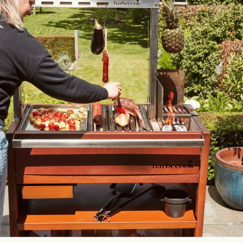 Person grilling food on a Barbecook grill outdoors